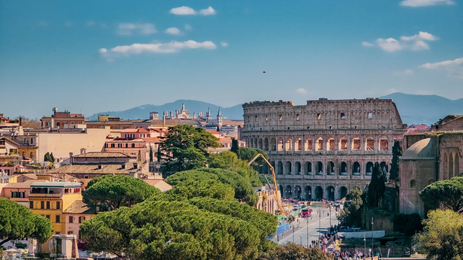 Stadsgezicht van Rome met het Colosseum, het historisch centrum en parasoldennenbomen